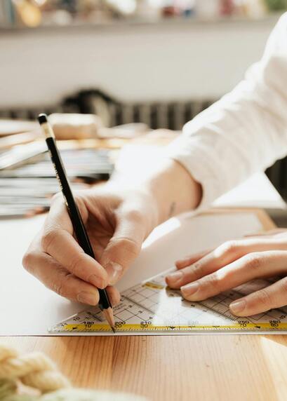 Persona usando regla de medición profesional sobre papel con precisión milimétrica en trabajo de diseño